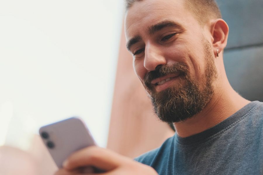 Ein Mann schaut auf sein Smartphone und nutzt digitale Angebote